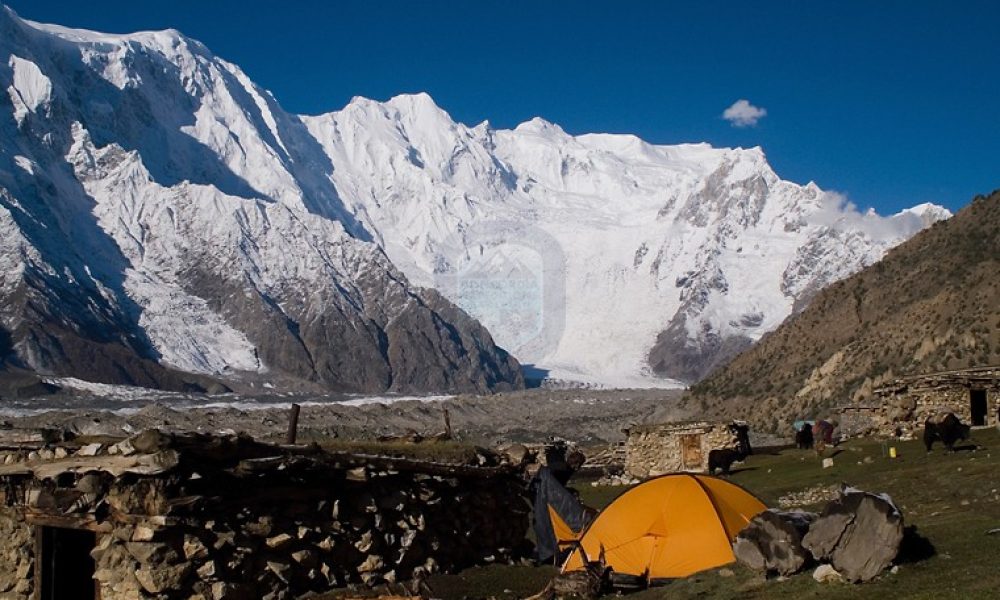 “Trekkers on Batura Glacier trail with Hunza mountains behind”